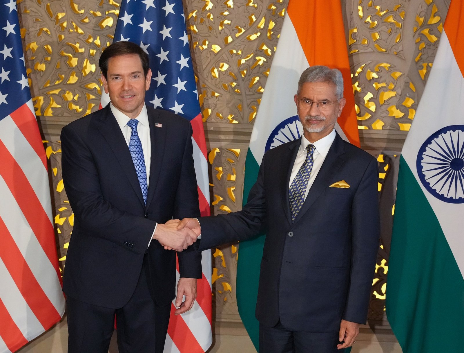US Secretary of State Marco Rubio shakes hands with Indian Foreign Minister S. Jaishankar in Mumbai, with US and Indian flags behind them