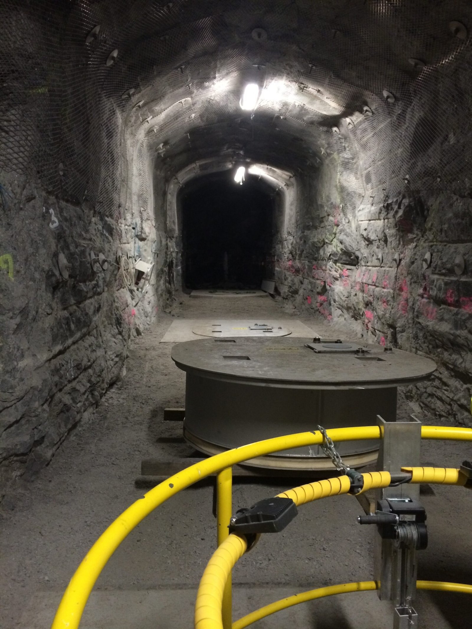 pilot cave at final depth, Onkalo repository tunnel, underground rock gallery with lighting and equipment