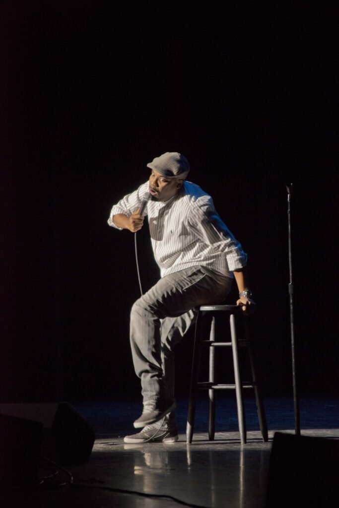 Kevin Hart performing on stage with a microphone at Texas A&M in 2014