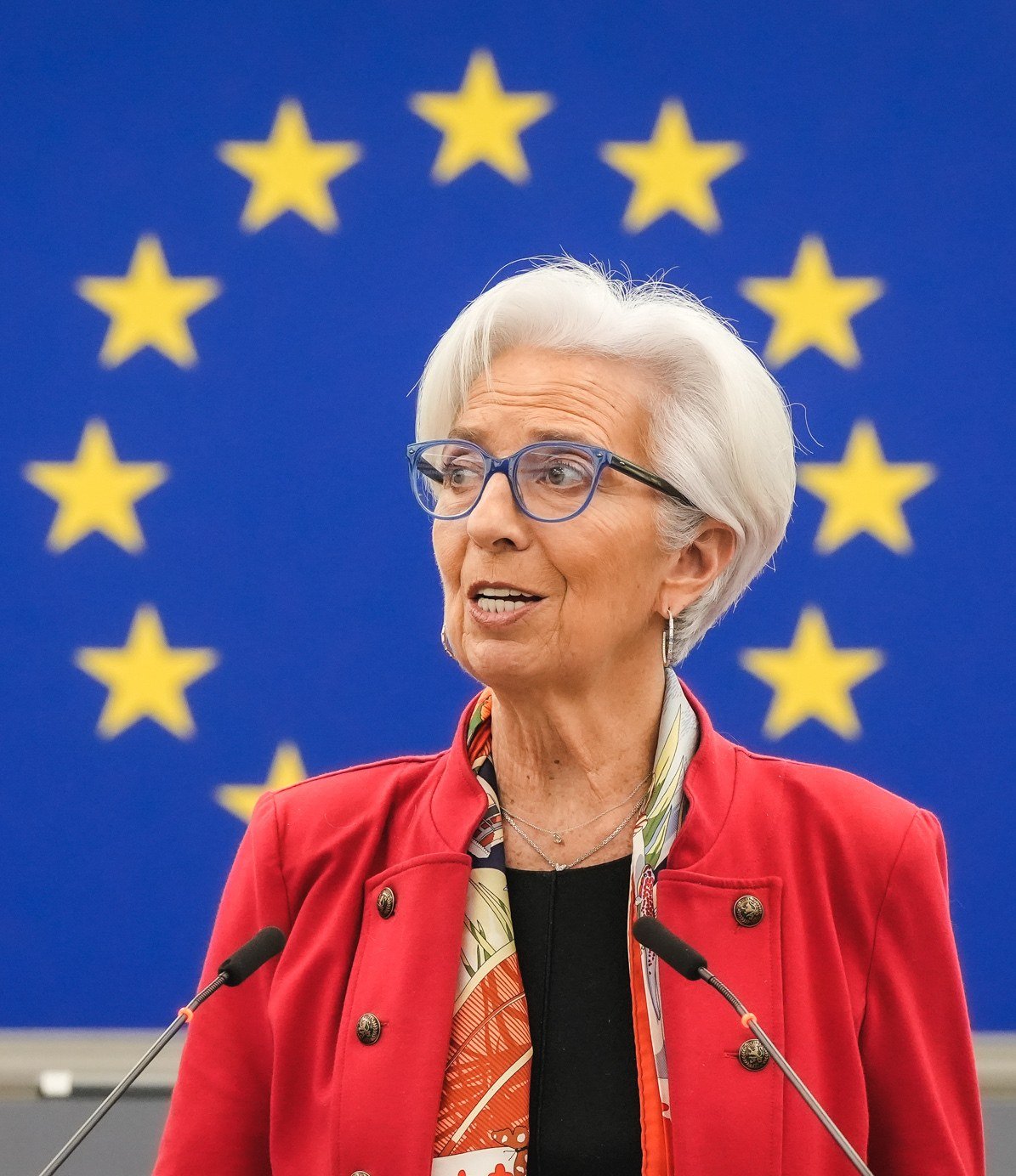 Christine Lagarde speaking at a podium in front of European Union flags